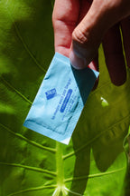 Sobre de aspartame Dilox en mano sobre hoja verde